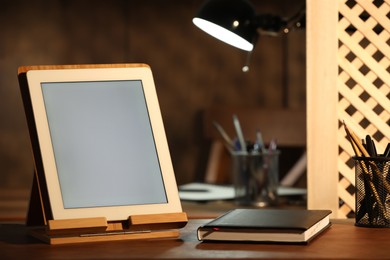 Photo of Modern tablet and planner on wooden table indoors. Space for text