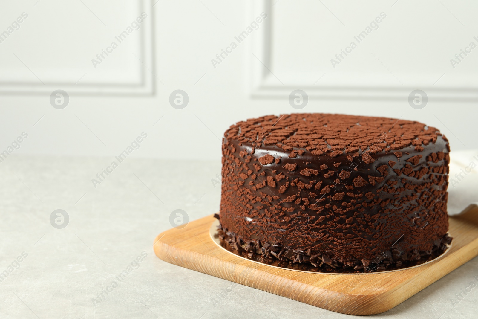 Photo of Delicious chocolate truffle cake on light grey table, space for text