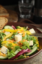 Delicious salad with lentils, vegetables and cheese on wooden table, closeup