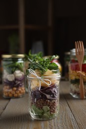 Photo of Glass jar with healthy meal on wooden table