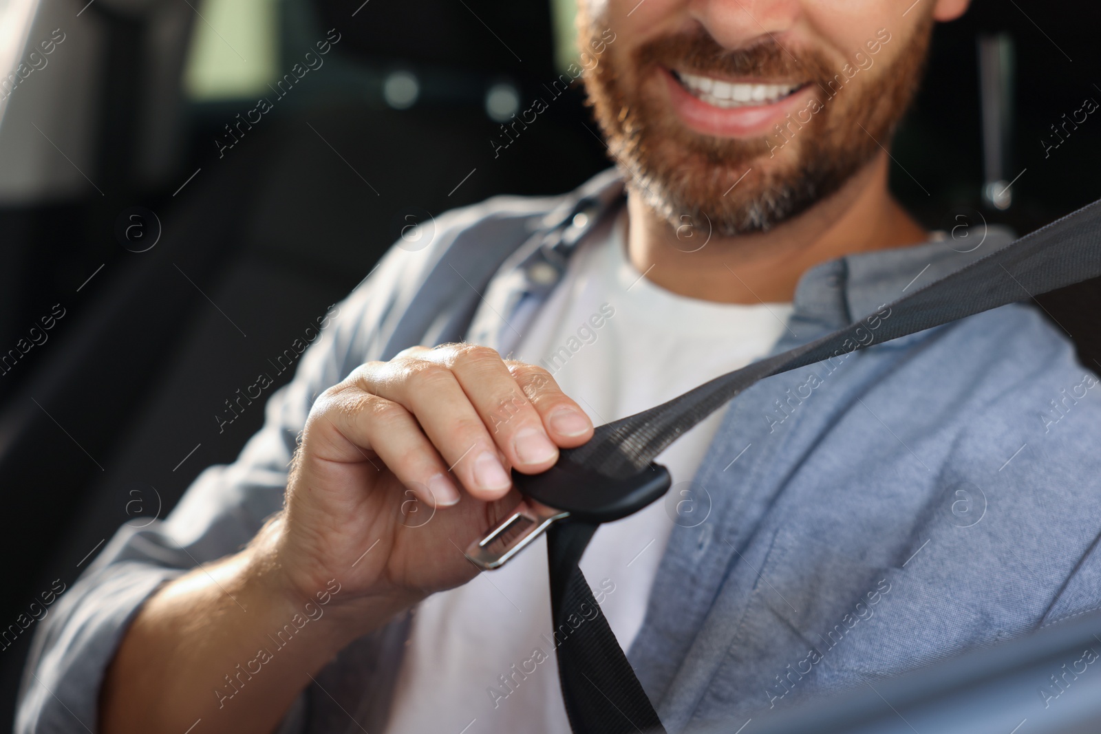 Photo of Man pulling seat belt in car, closeup