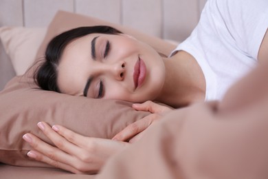 Photo of Woman sleeping in comfortable bed with beige linens