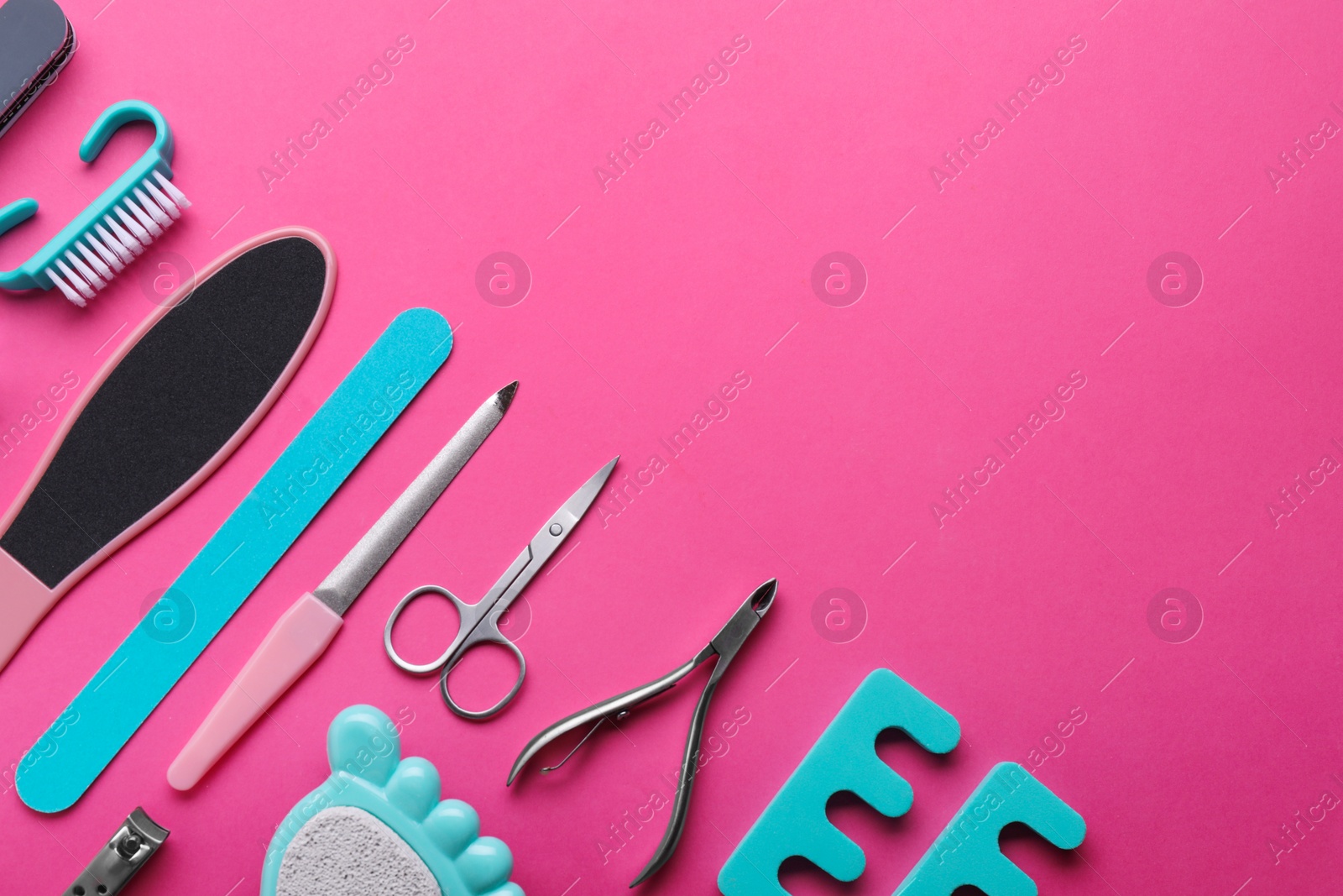 Photo of Set of pedicure tools on pink background, flat lay. Space for text