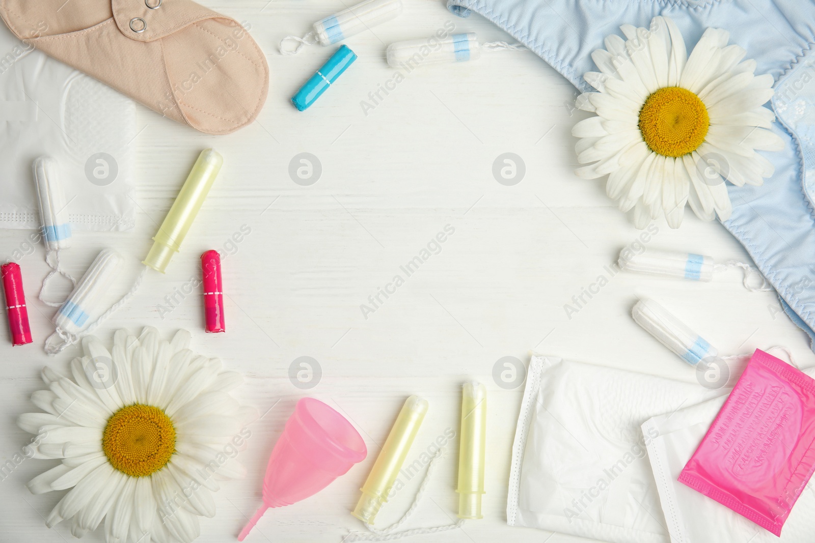 Photo of Frame of tampons and other menstrual hygienic products on white wooden background, flat lay. Space for text