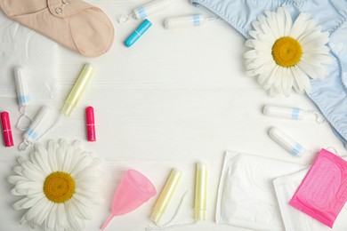 Frame of tampons and other menstrual hygienic products on white wooden background, flat lay. Space for text