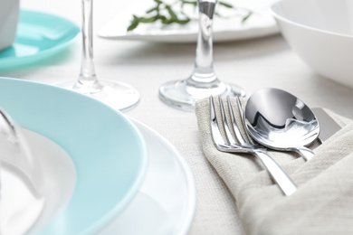 Photo of Elegant cutlery with green leaves on table, closeup. Festive setting