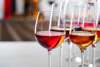 Photo of Glasses with different wines on blurred background, closeup. Space for text