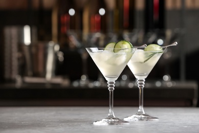 Photo of Glasses of tasty cucumber martini on bar counter, space for text