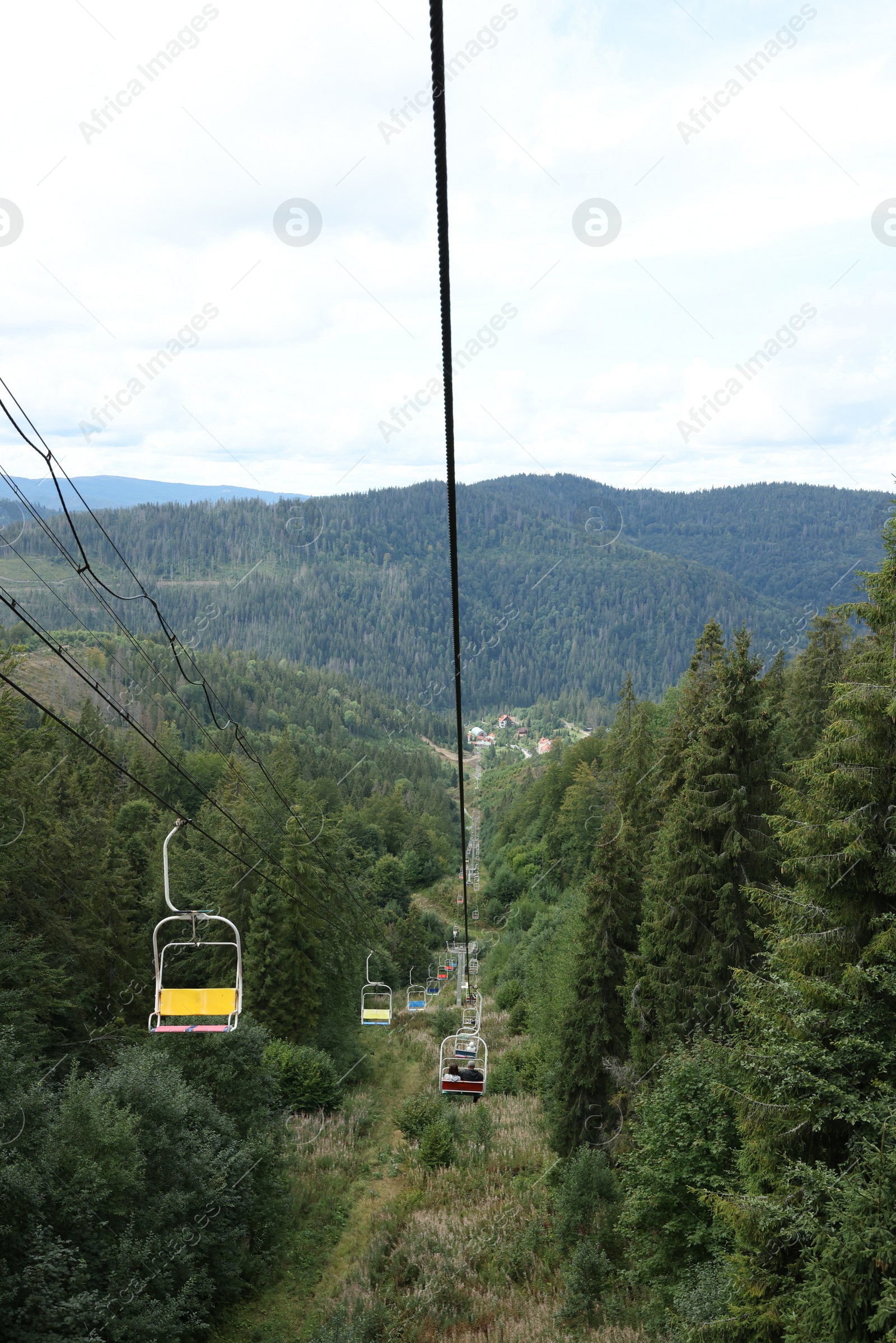 Photo of Ski lift and green trees at mountain resort