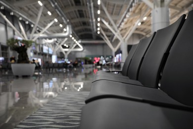 Waiting area with seats in airport terminal, closeup. Space for text