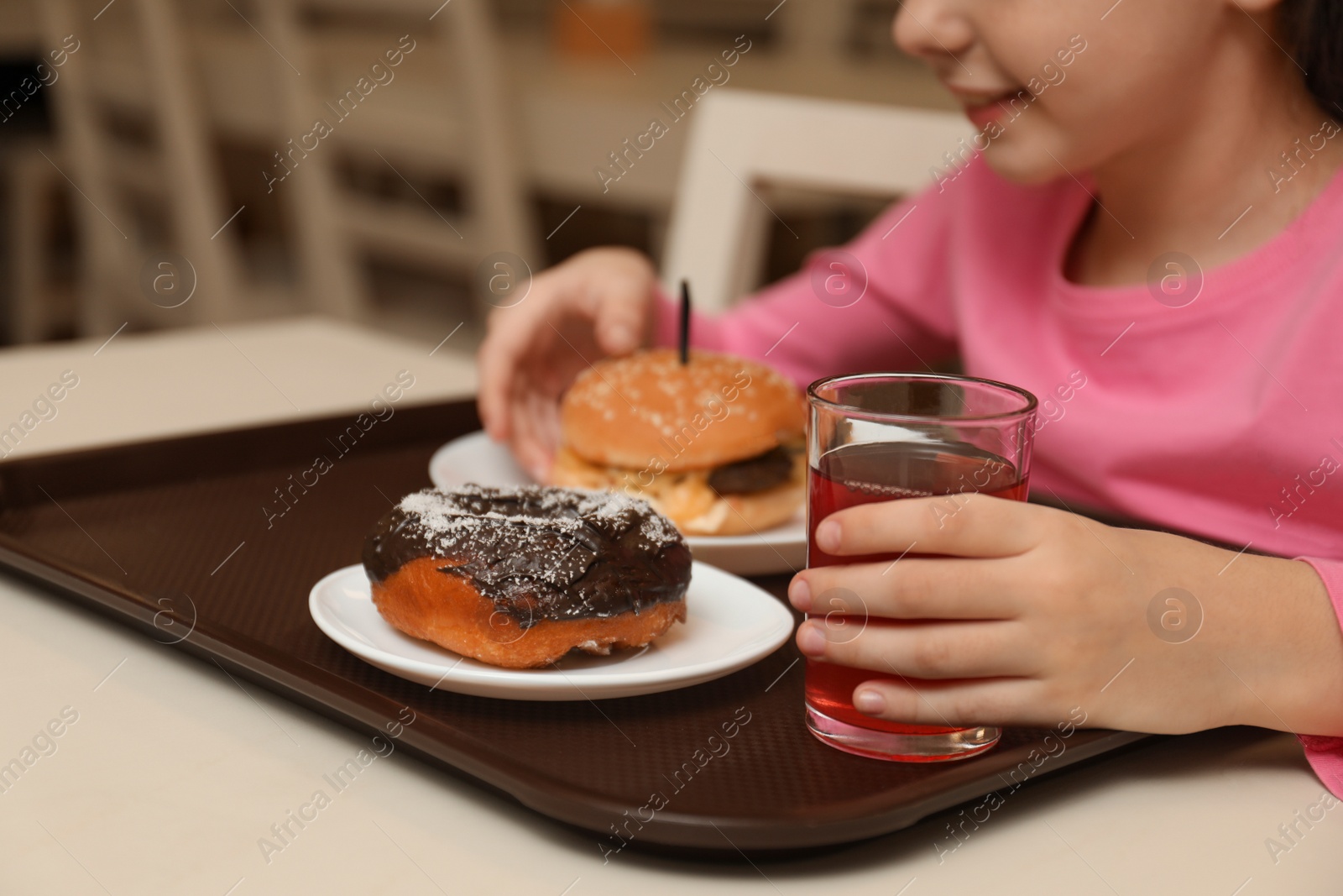 Photo of Little girl with tasty food at table in school canteen, closeup
