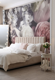 Beautiful room interior with large bed, mirror and floral pattern on wall