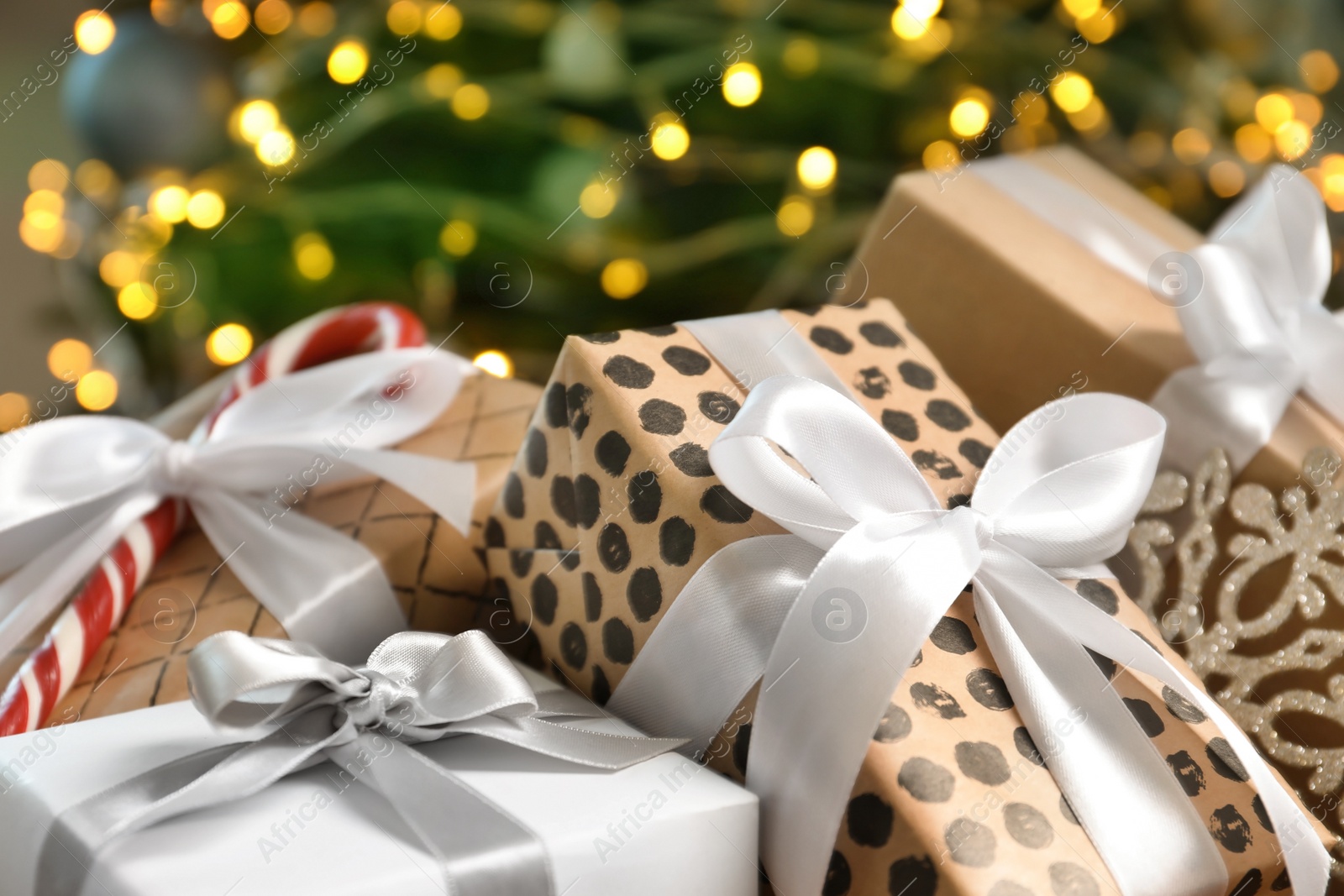 Photo of Beautiful gift boxes and blurred Christmas tree on background