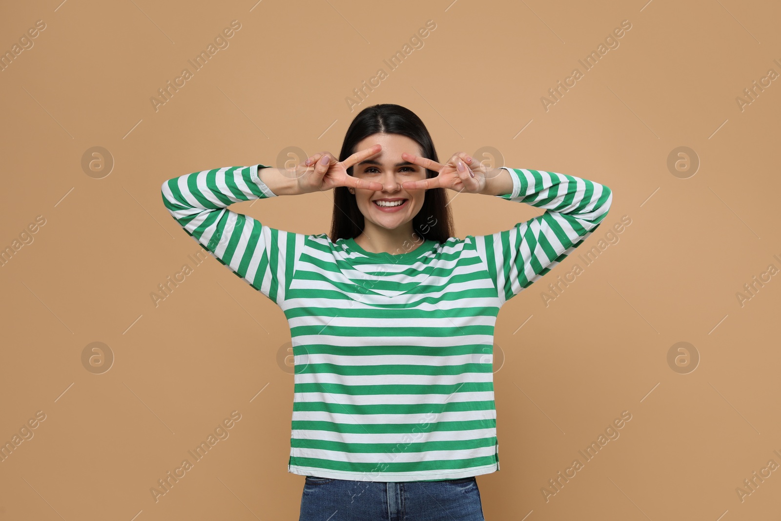 Photo of Emotional actress performing on beige background. Film industry