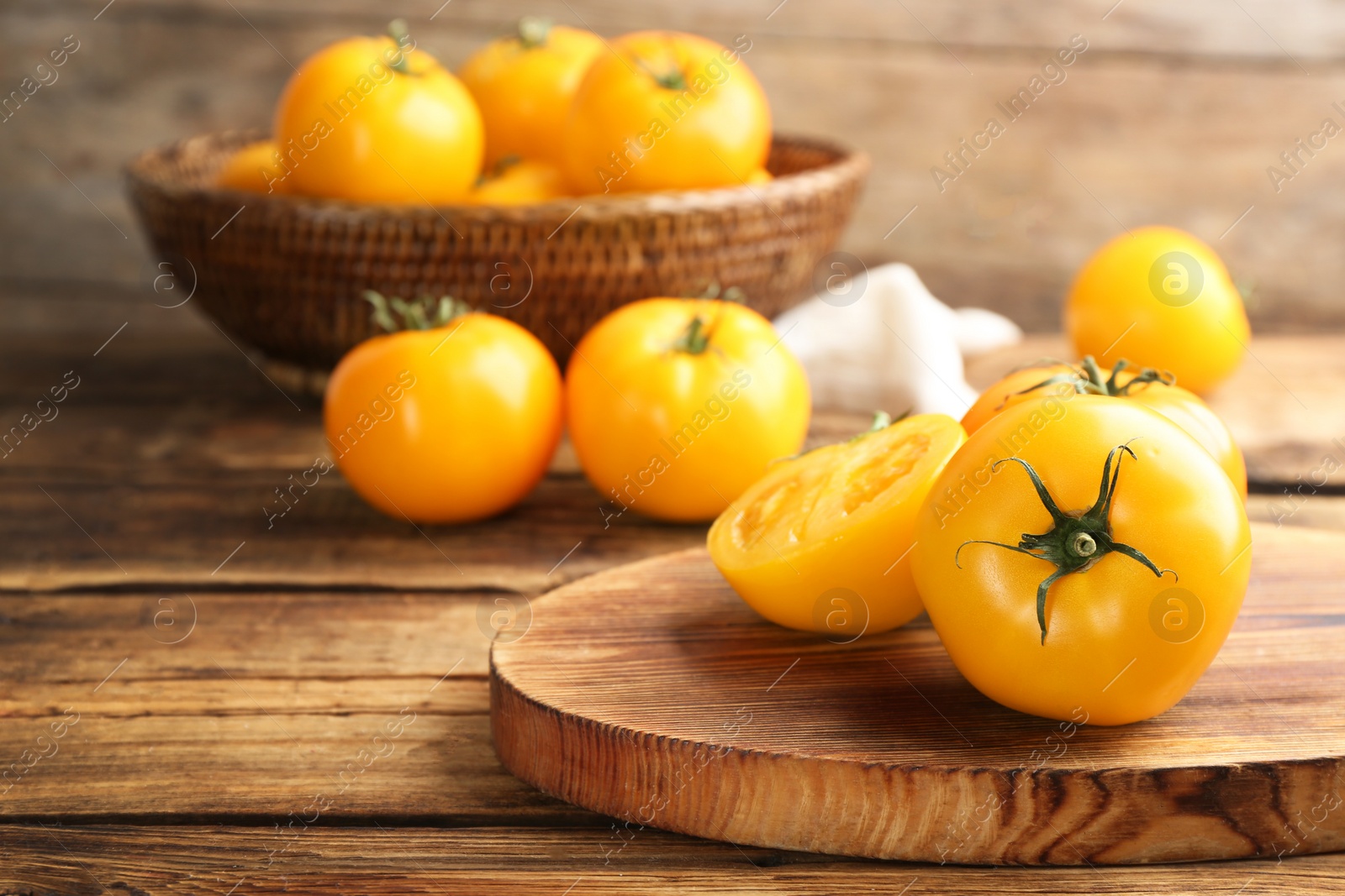 Photo of Delicious ripe yellow tomatoes on wooden table