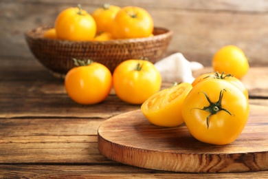 Photo of Delicious ripe yellow tomatoes on wooden table