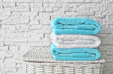 Photo of Stack of clean towels on wicker basket