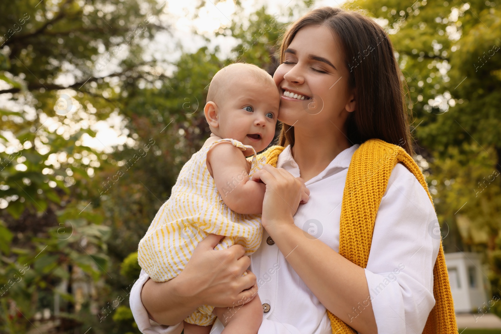 Photo of Happy mother with adorable baby walking on sunny day