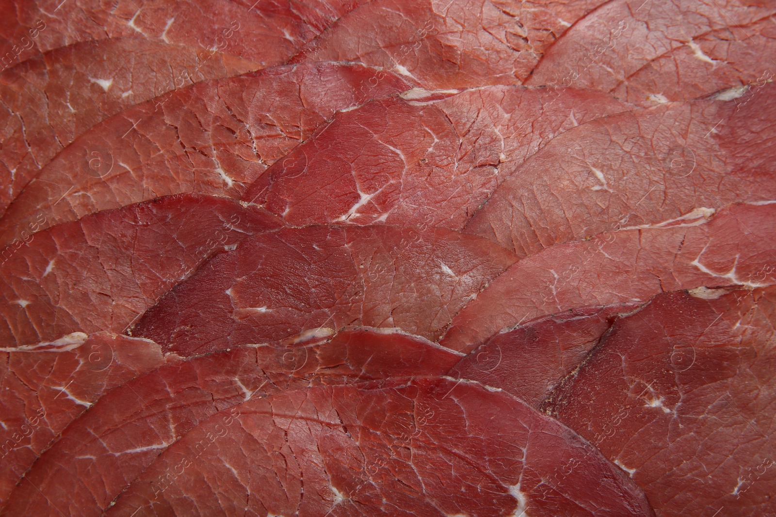 Photo of Slices of tasty bresaola as background, top view