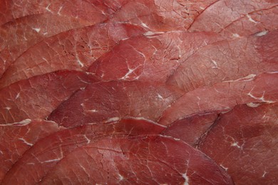 Photo of Slices of tasty bresaola as background, top view