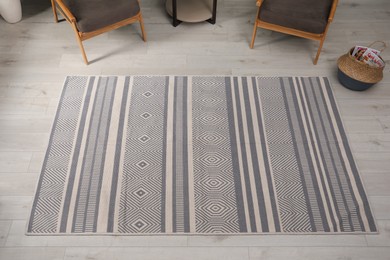 Stylish rug with pattern on floor in room, above view