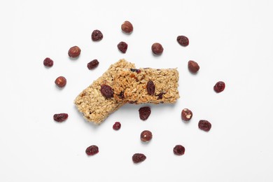 Tasty granola bars with dry cherries and nuts on white background, flat lay