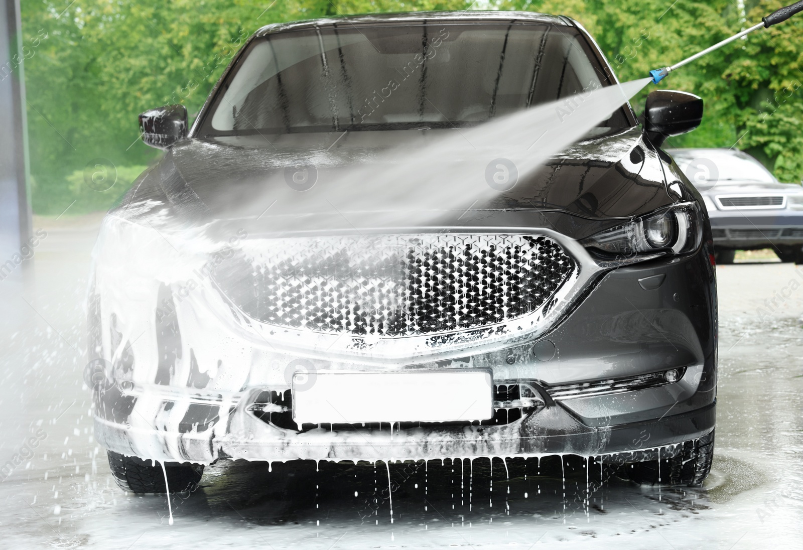 Photo of Washing auto with high pressure water jet at outdoor car wash