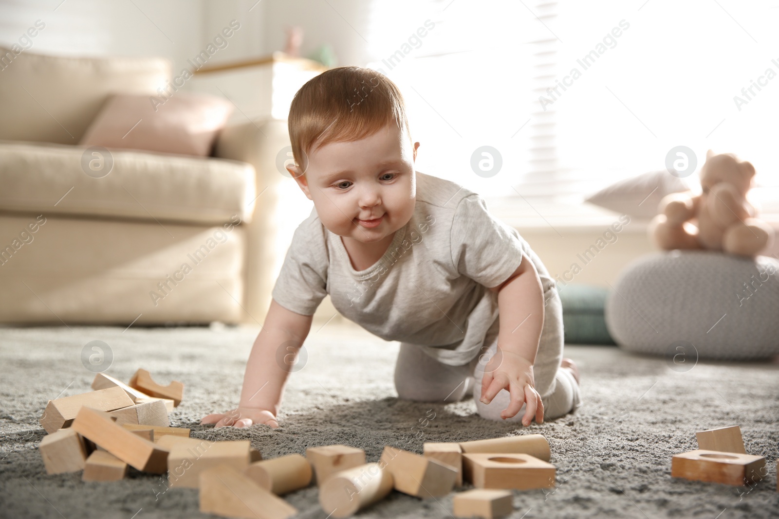 Photo of Cute baby playing with wooden blocks at home