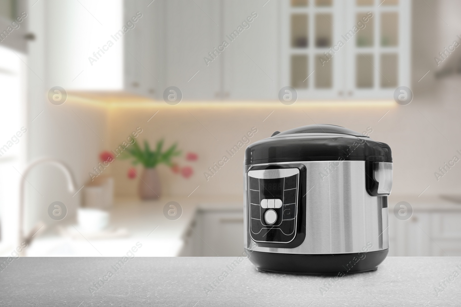 Image of Modern electric multi cooker on table in kitchen. Space for design