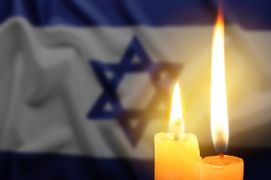 Image of Burning candles against flag of Israel, closeup