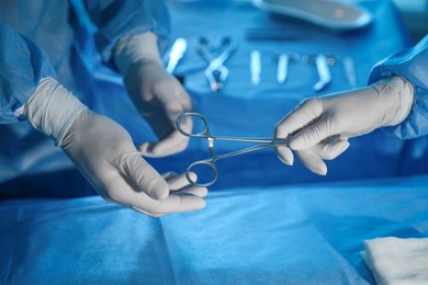 Photo of Professional surgeons with instruments performing operation in clinic, closeup