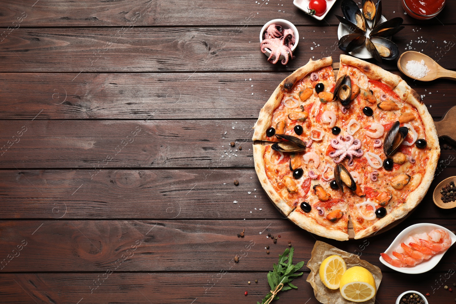 Photo of Tasty pizza with seafood and ingredients on wooden table, flat lay. Space for text