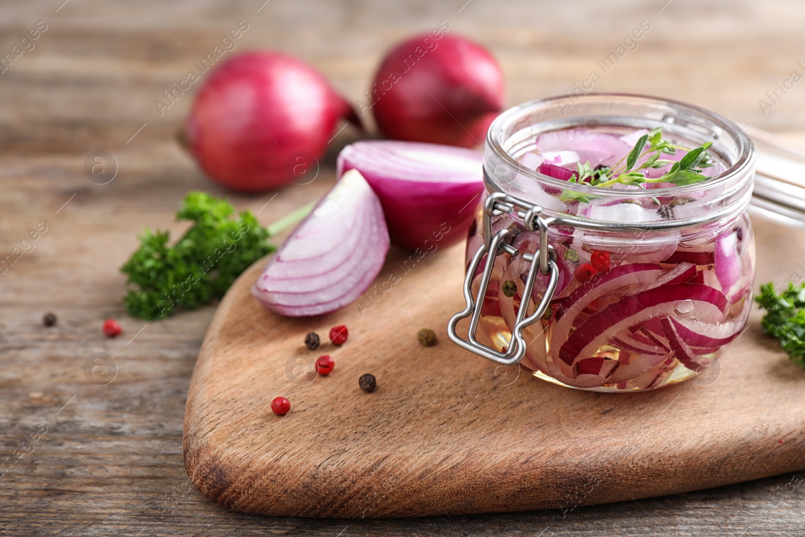 Photo of Jar of pickled onions on wooden table