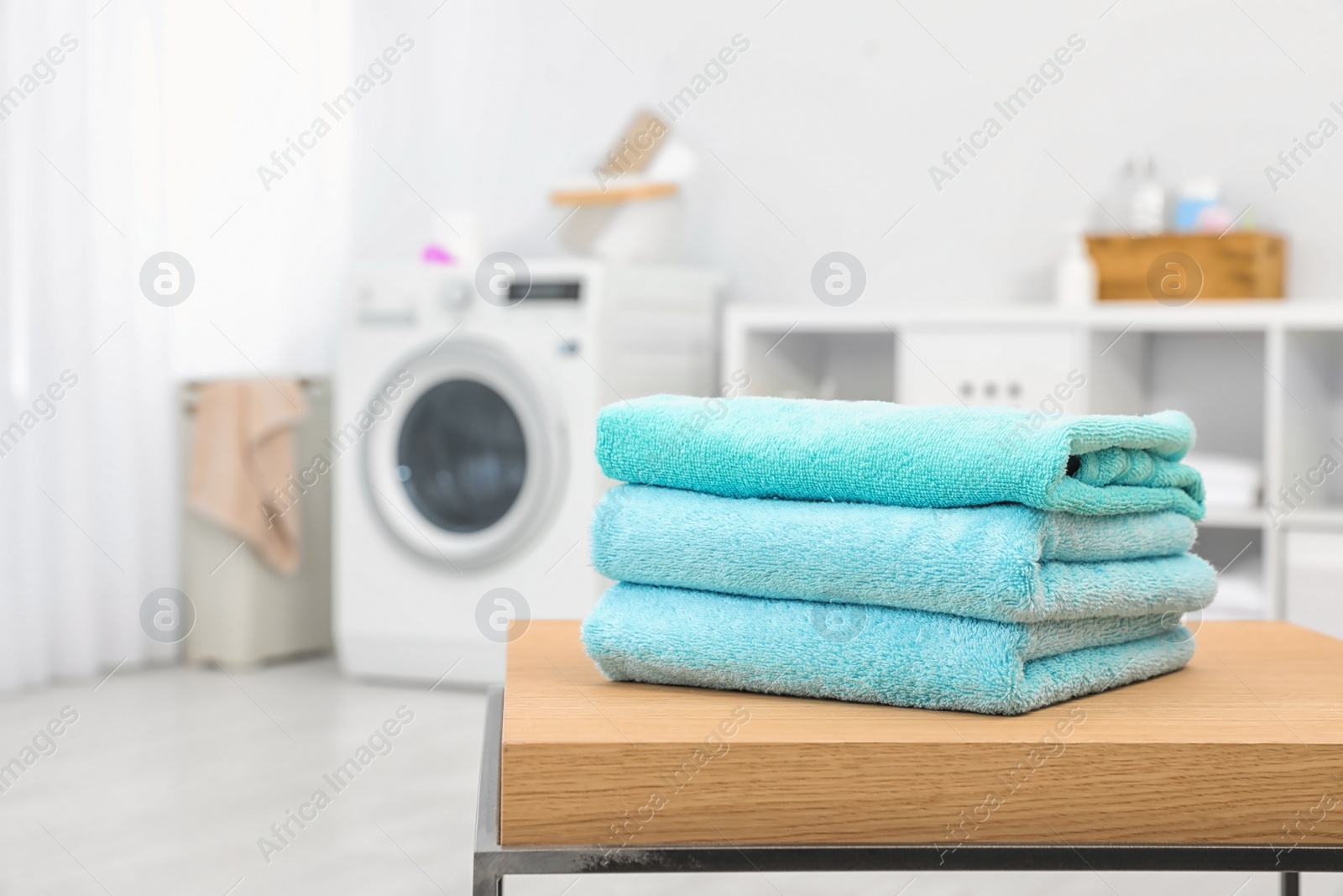 Photo of Stack of clean towels on table in bathroom.  Space for text