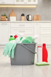 Photo of Different cleaning supplies in bucket on floor