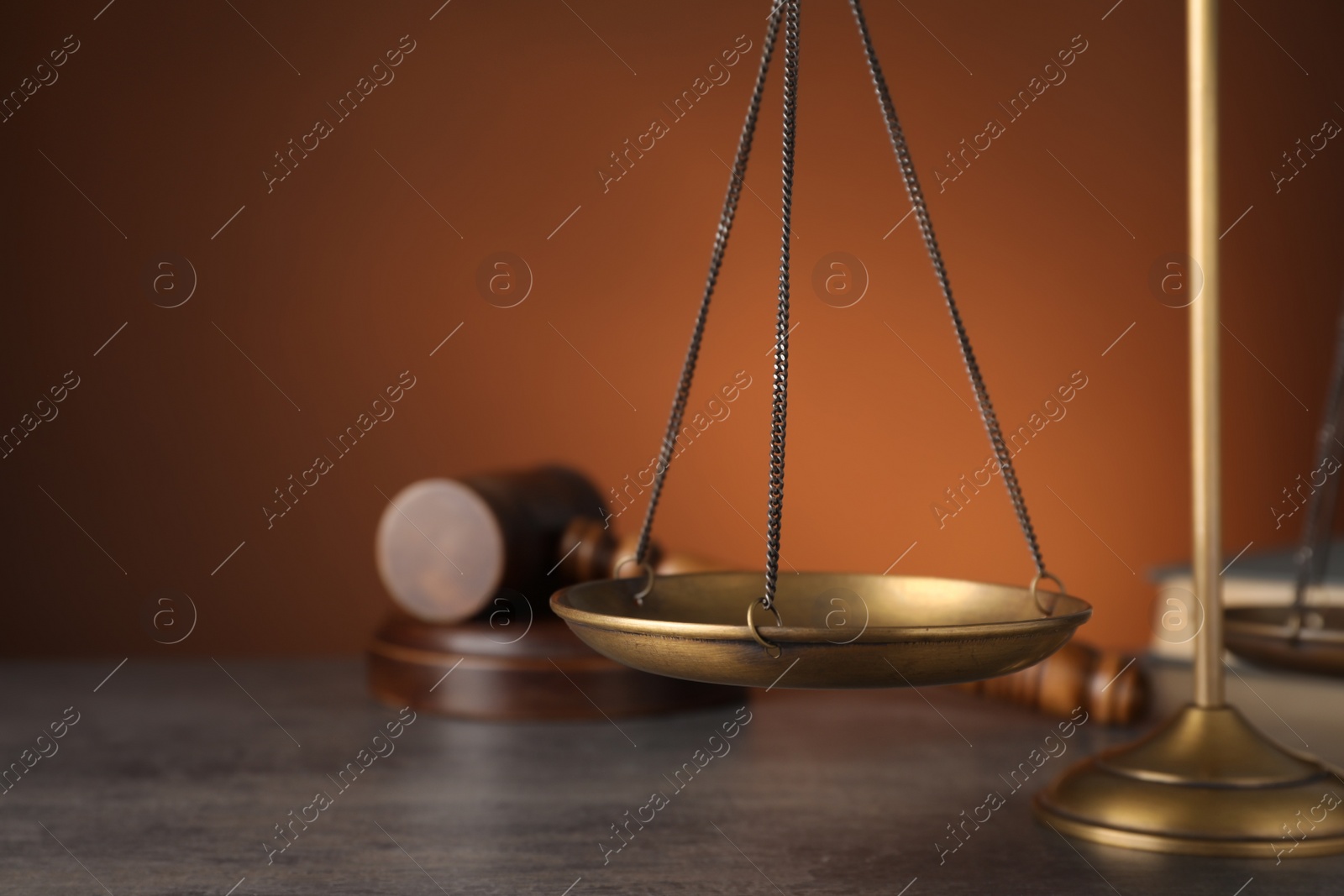 Photo of Scales of justice on grey table, closeup. Space for text