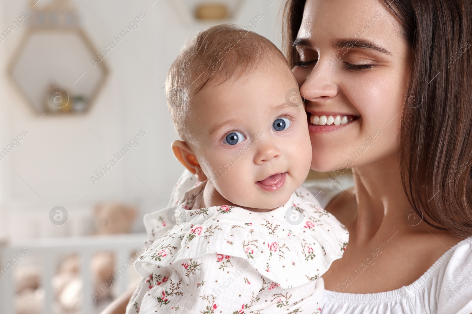 Photo of Happy young mother with her baby daughter at home, closeup