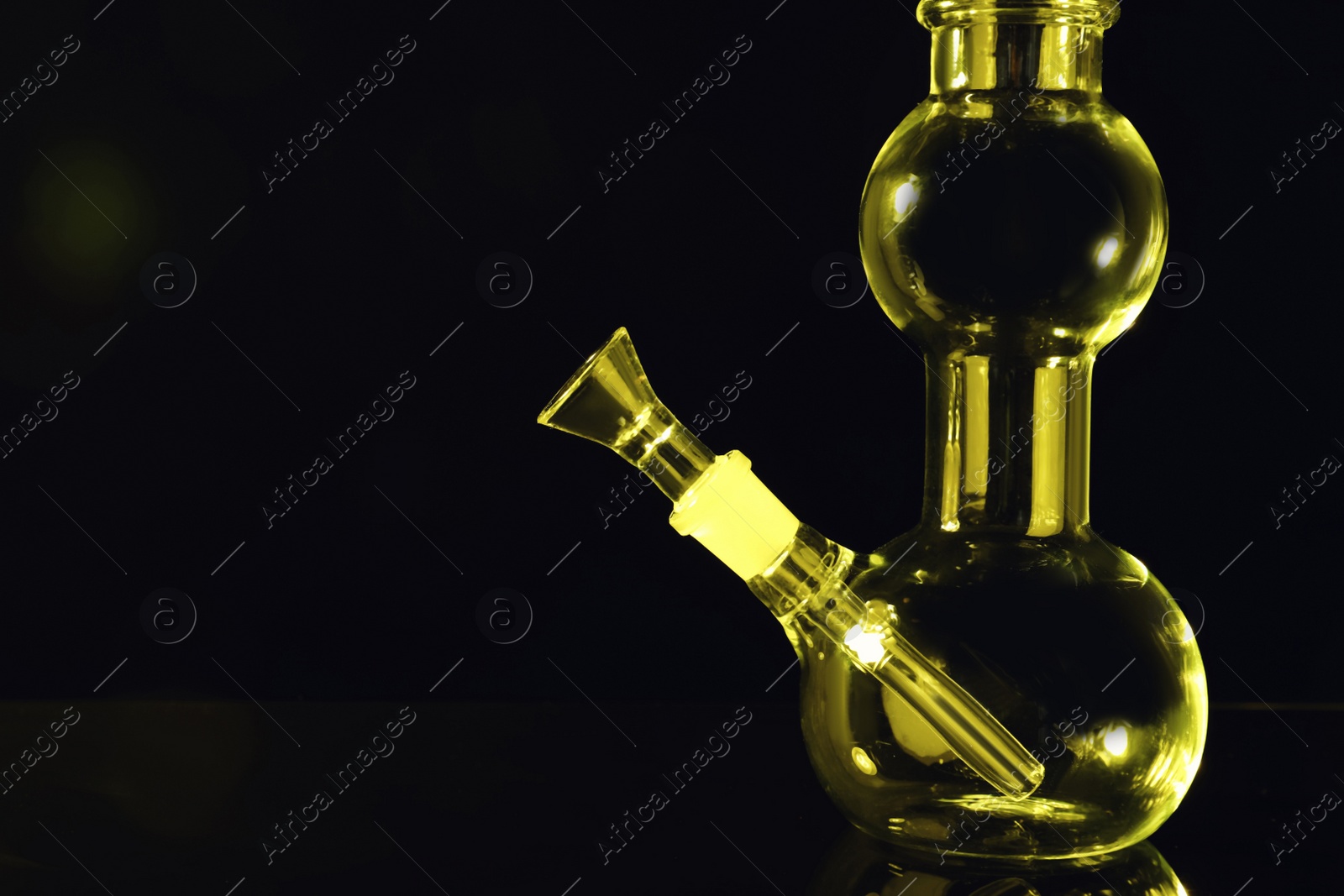 Photo of Closeup view of glass bong on black background, space for text. Smoking device