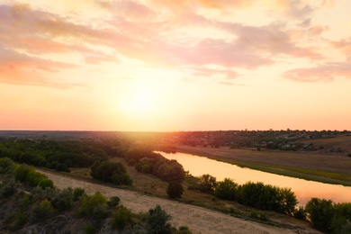 Amazing cloudy sky over fields and river, aerial view. Sunset landscape