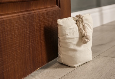 Photo of Stuffed bag holding wooden door at home