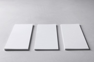 Photo of Blank business cards on light grey textured table, closeup. Mockup for design