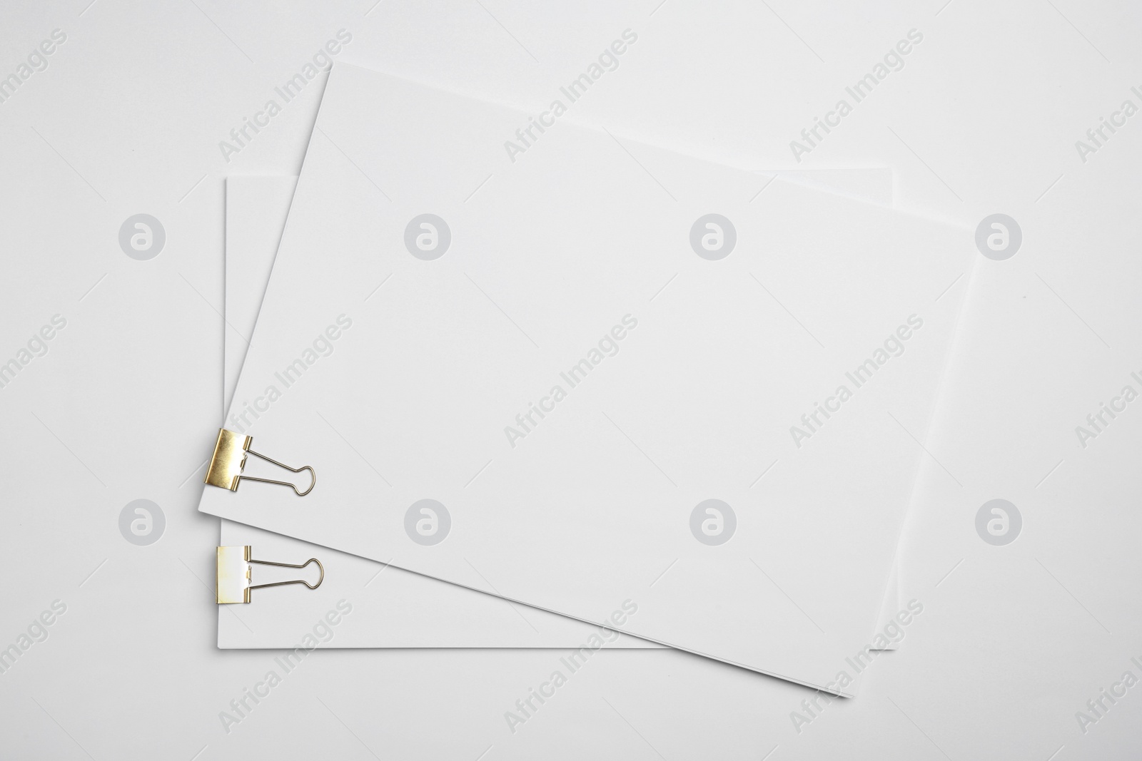 Photo of Sheets of paper with clips on white background, top view