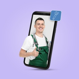 Plumber looking out of smartphone and showing thumbs up on light violet background
