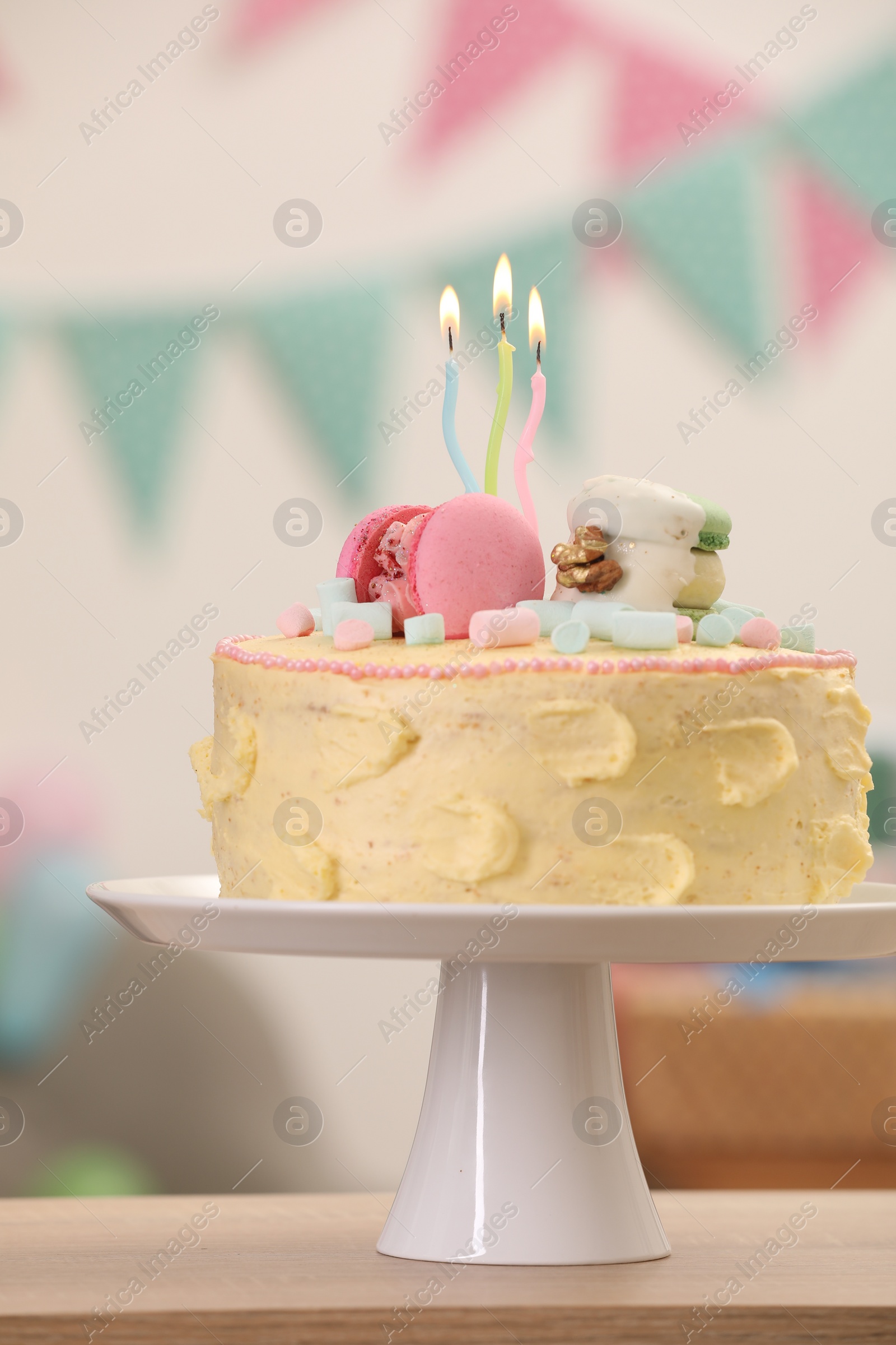 Photo of Delicious cake decorated with macarons and marshmallows on wooden table against blurred background, closeup