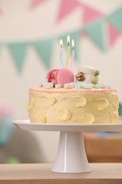 Photo of Delicious cake decorated with macarons and marshmallows on wooden table against blurred background, closeup