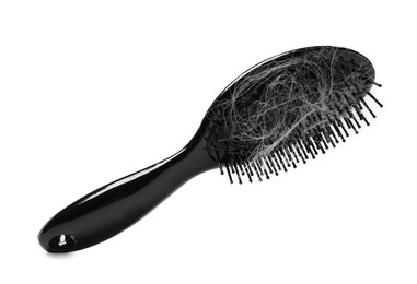 Photo of Brush with lost hair in air on white background