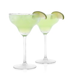 Delicious Margarita cocktail in glasses, salt and lime isolated on white