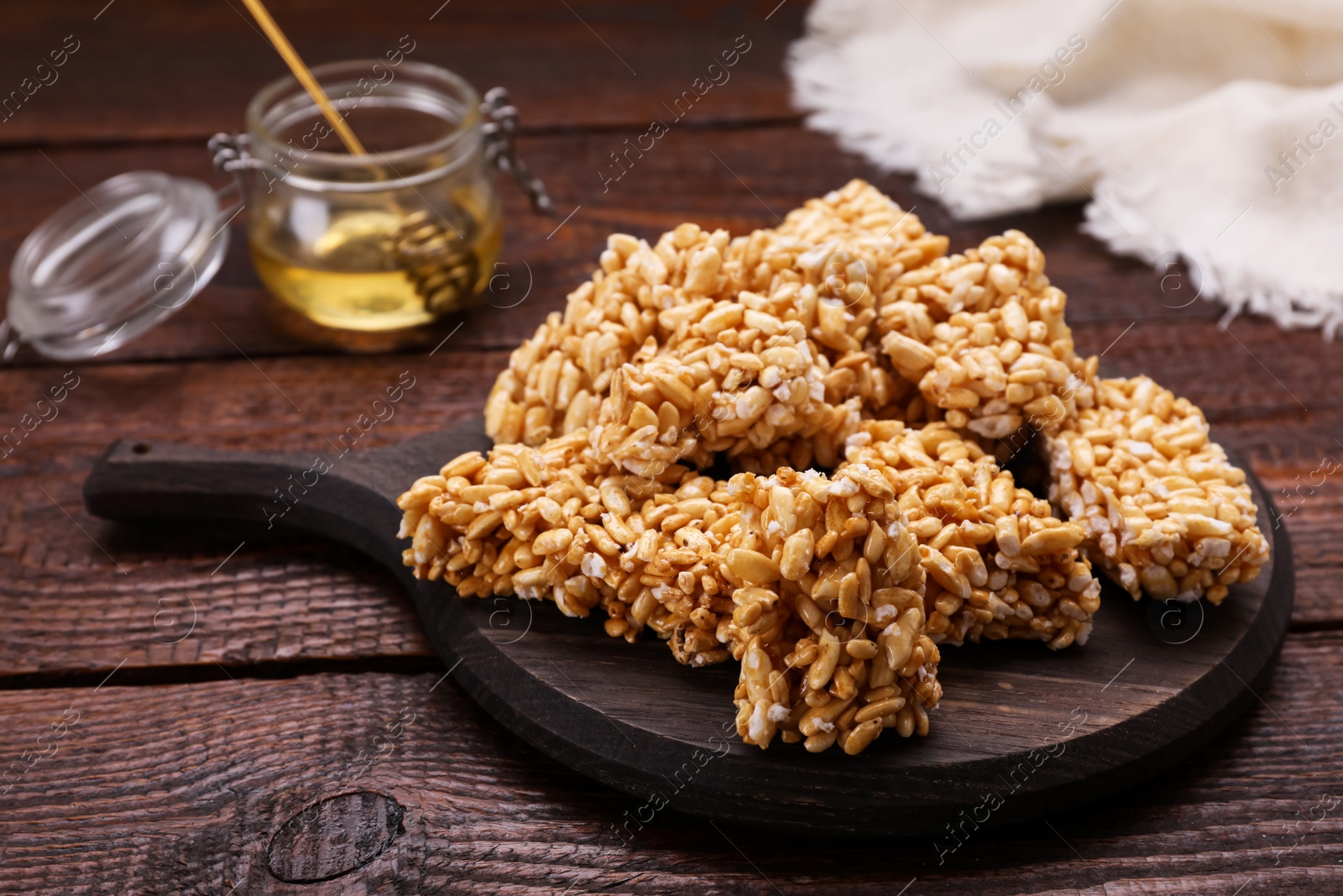 Photo of Board with puffed rice bars (kozinaki) on wooden table