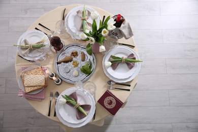 Photo of Festive Passover table setting with Torah, top view. Pesach celebration