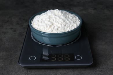 Photo of Electronic scales with flour on black table